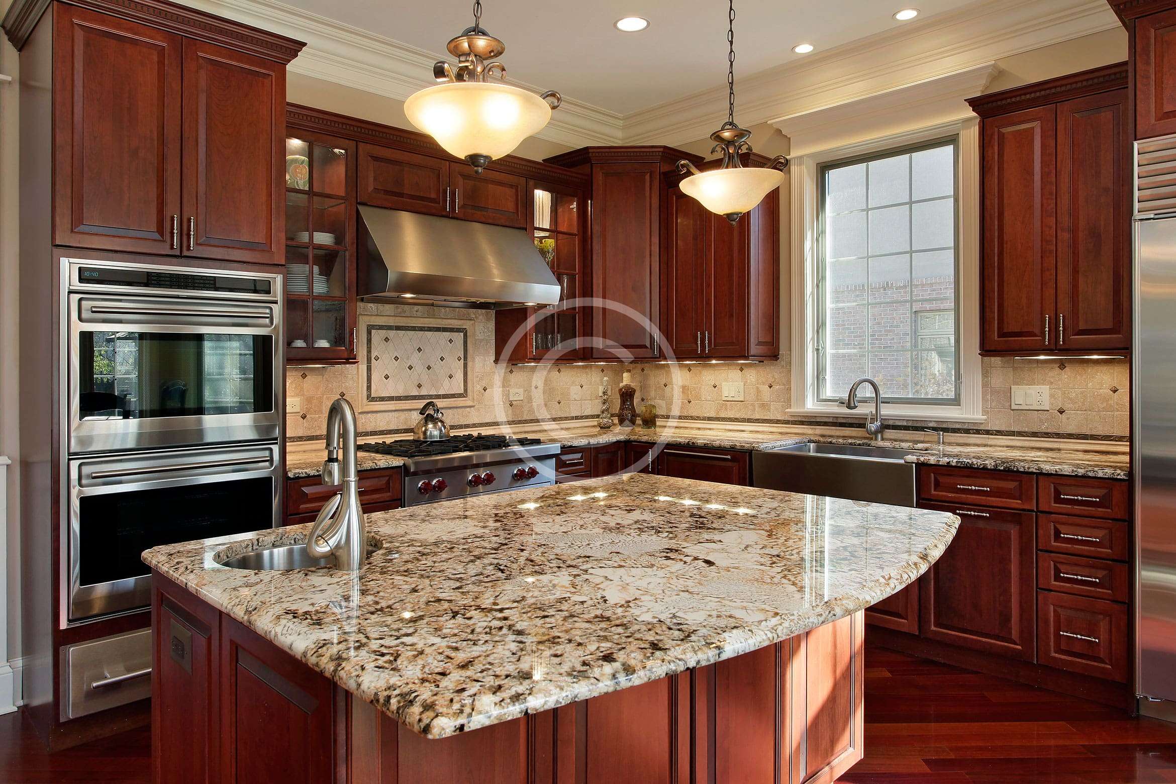 A kitchen with granite counter tops and wooden cabinets.