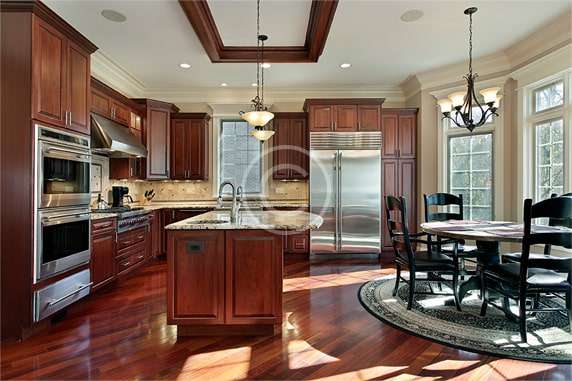 A kitchen with wood floors and wooden cabinets